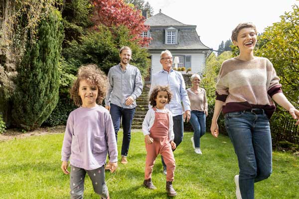 Glückliche Familie mit Großeltern im eigenen Garten